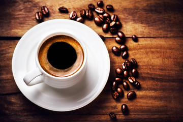 Poster - Coffee cup with coffee beans  on wooden background with copyspac