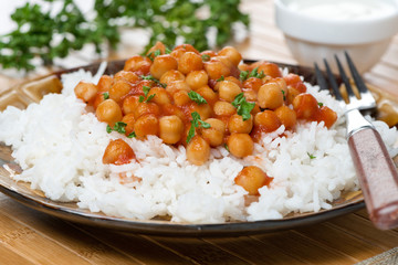 Wall Mural - white rice with chickpeas in tomato sauce, close-up