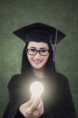 Female student giving bright light bulb