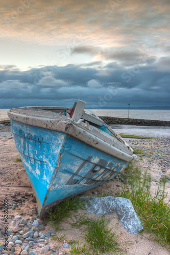 Fototapeta na wymiar Damaged fishing boat on the empty beach in Morecambe, HDR Image