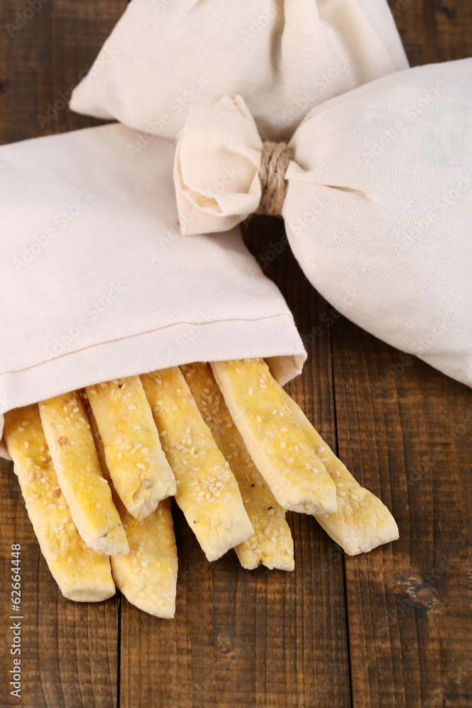 Bread sticks  in sack on wooden background