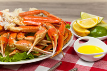 Snow Crab Legs With Fresh Lemon Slices And Butter Sauce