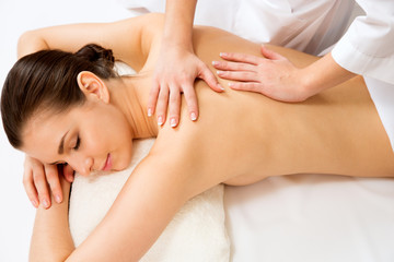 Wall Mural - Masseur doing massage on the back of woman in the spa salon.