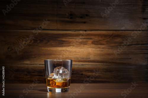 Cuadros en Lienzo glass of whiskey with ice on a wooden background