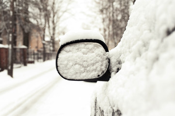 Car mirror covered of snow. Outside