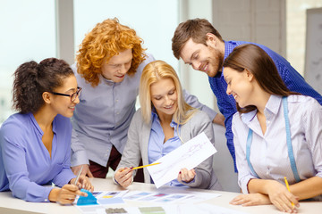 Canvas Print - smiling creative team looking at sketch