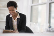 © Mint Images - Business People. A Woman In A Black Jacket Using A Digital Tablet.