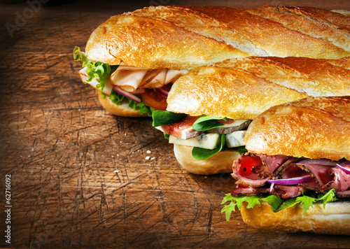 Fotografie, Obraz Three tasty baguettes with savory fillings
