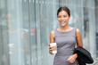 Business woman walking drinking coffee