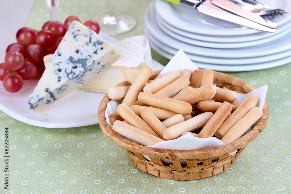 Composition with cheese, grape and bread sticks