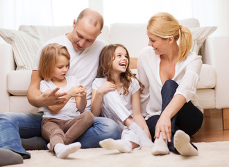 Canvas Print - parents and two girls sitting on floor at home