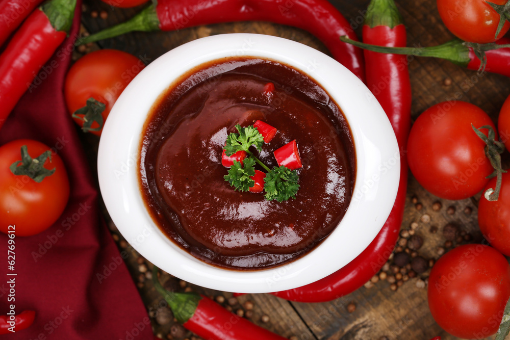 Tomato sauce in bowl on wooden table close-up