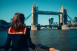 © LoloStock - Young woman on boat looking at Tower Bridge in London