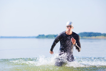 Triathlete running out of the water