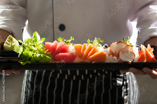 Naklejka samoprzylepna Sashimi, mundur szefa kuchni trzymającego naczynie japońskiego sashimi