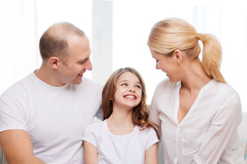 Canvas Print - smiling parents and little girl at home