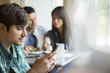 © Mint Images - Three people seated at a cafe table.