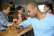 © goodluz - Man sitting at snack bar table checking messages