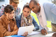 © goodluz - Group of students using tablet outside school building