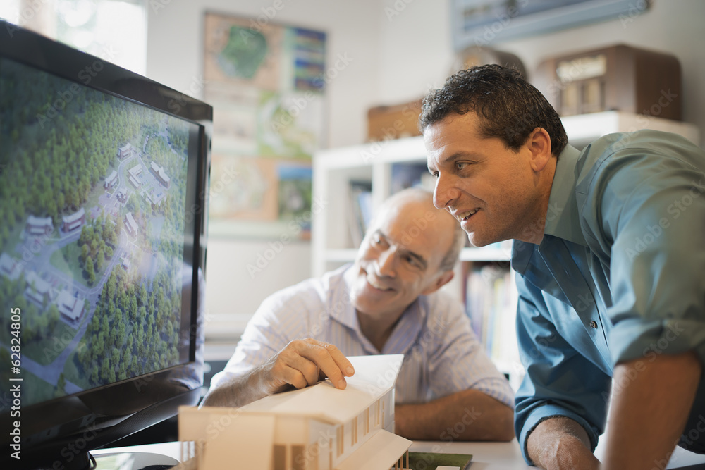 Two architects working on a green construction project, using computer ...