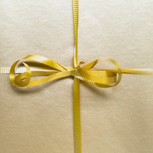 Close Up Of A Tied Bow And Gold Ribbon From A Wrapped Gift.