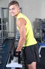 Wall Mural - Guy with dumbbells in gym