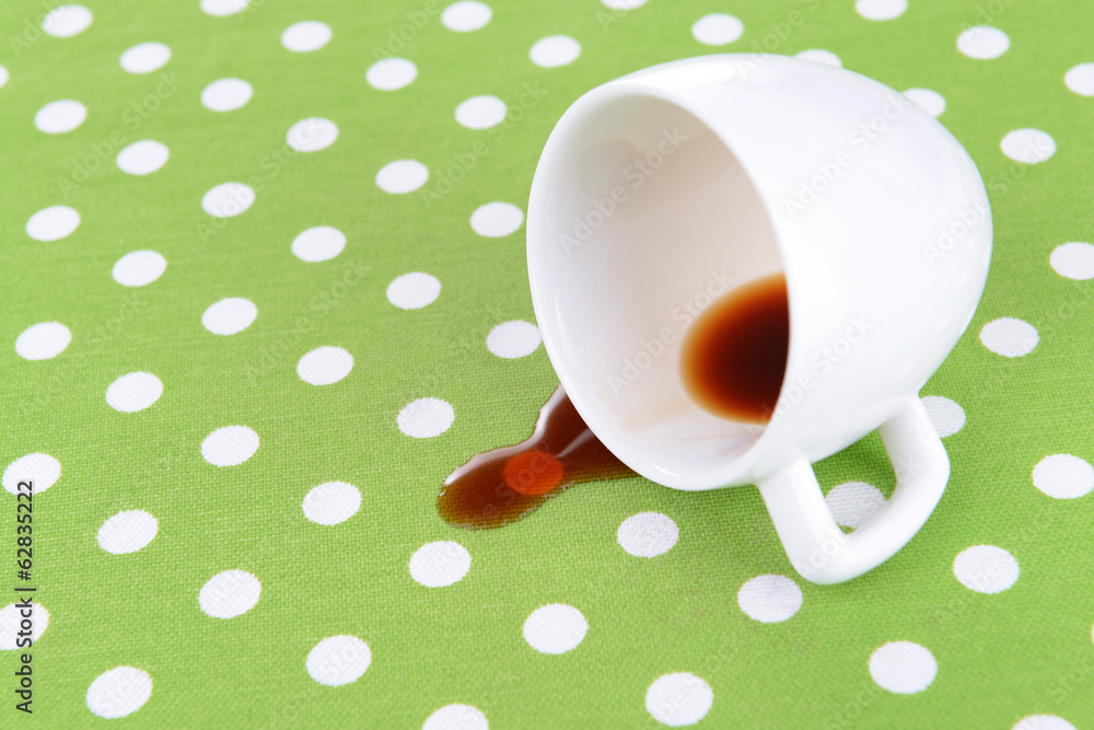 Overturned cup of coffee on table close-up