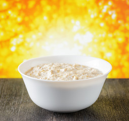 Canvas Print - Bowl of oat porridge on nature background