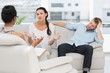 © WavebreakMediaMicro - Angry couple sitting on couch talking to therapist