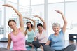 © WavebreakmediaMicro - Class stretching hands at yoga class