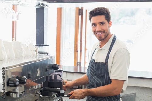 Fotografie, Obraz Smiling barista preparing espresso at coffee shop