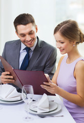 Wall Mural - smiling couple with menu at restaurant