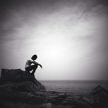 Man Sitting Alone On The Beach