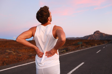 Wall Mural - Back pain - Athletic running man with injury