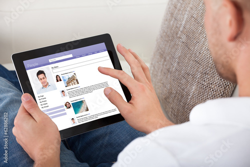 Fotografia Man looking at personal profiles on a tablet