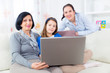 © Mediteraneo - grandmother mother and daughter using laptop at home
