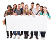 © Andrey Popov - College Students Displaying Blank Billboard