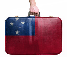 Tourist hand holding vintage leather travel bag with flag of Sam