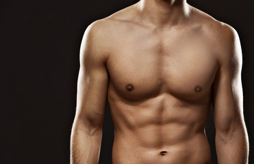 Close up of sexy male's torso, isolated on black