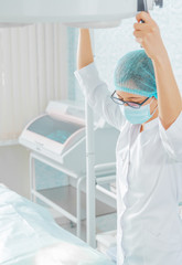 Poster - Nurse holds a surgical lamp