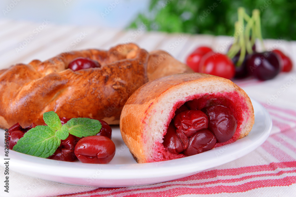 Fresh baked pasties with cherry on plate on table close-up