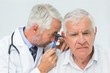© WavebreakMediaMicro - Male doctor examining senior patient's ear