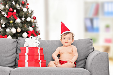 Canvas Print - Little baby with Santa hat sitting on couch