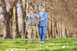 © Ljupco Smokovski - Senior and a male nurse walking in park