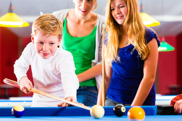 Familie spielt Poolbillard oder Billard