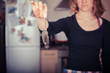 Woman holding a dead mouse in her kitchen