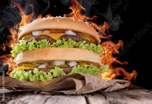 Naklejka samoprzylepna Pyszny hamburger z płomieniami ognia