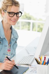 Wall Mural - Blonde happy designer using digitizer at her desk