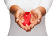 © Syda Productions - hands holding red AIDS awareness ribbon