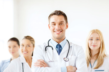 Poster - smiling male doctor in front of medical group